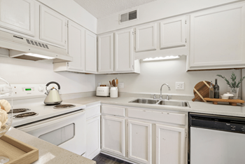 a kitchen with white cabinets and white appliances at Eastchester Ridge Apartments, High Point